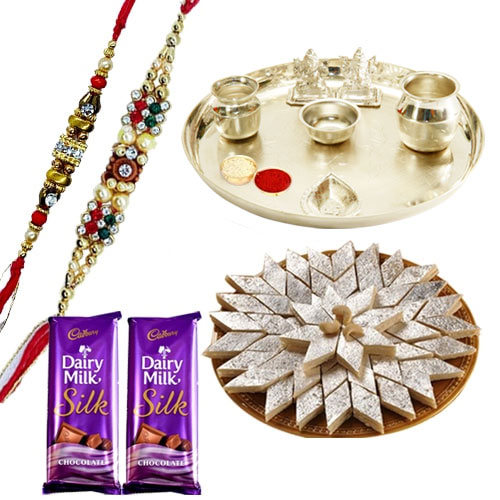 An Exclusive Gift Hamper with Silver Plated Thali Delicious Kaju Katli and Gift E Voucher from Raymond along with 2 free Rakhi,Roli Tika and Chawal